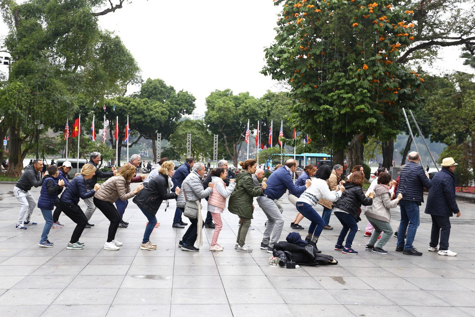 国际游客与当地市民锻炼身体。图自越通社
