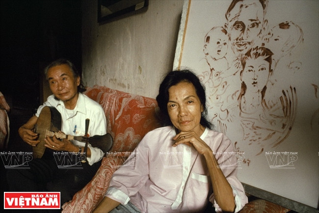越南著名画家、雕塑家叶明珠（左）与《胡伯伯与中南北三部儿童》血画。凯萨琳‧卡诺 摄