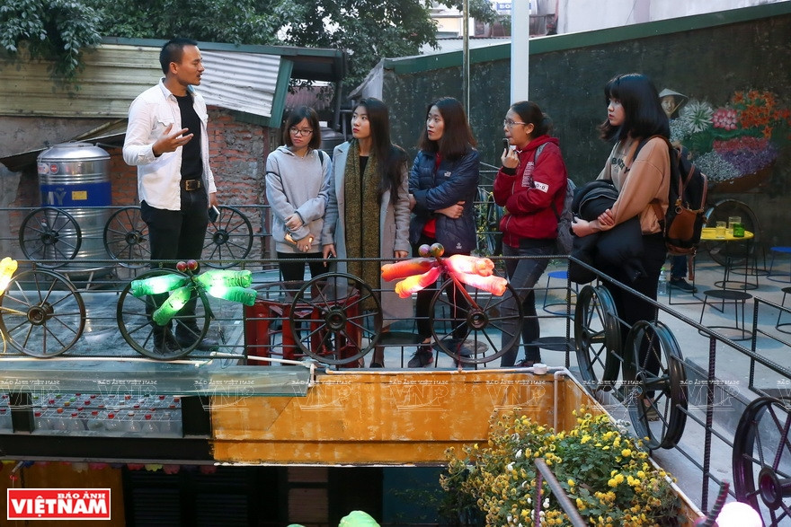 阮文诗先生（左一）与客人分享环保知识。图自越通社