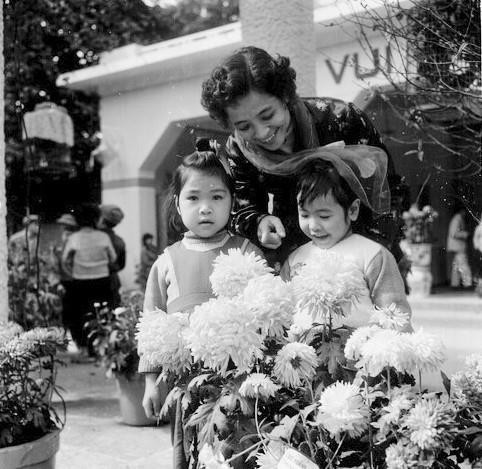 小朋友跟妈妈一起去参观春季花卉。图自越通社