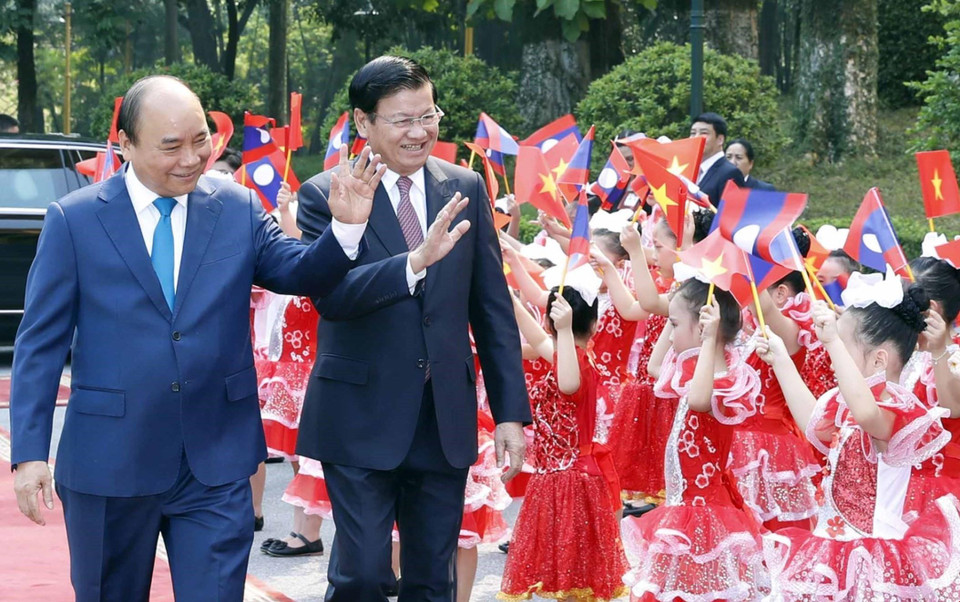 越南政府总理阮春福举行仪式 欢迎老挝政府总理通伦·西苏里访越。图为两位总理向儿童们挥手。越通社记者 统一 摄