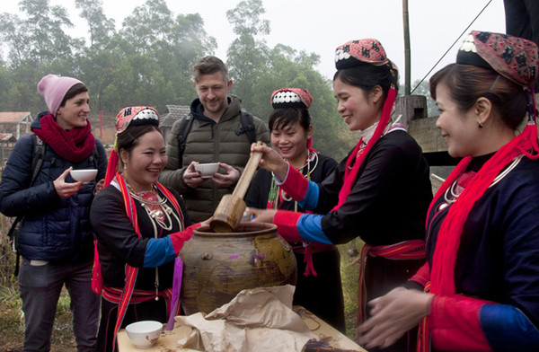 外国游客亲自体验广宁省少数民族同胞的文化特色。（图片来源：人民报网）