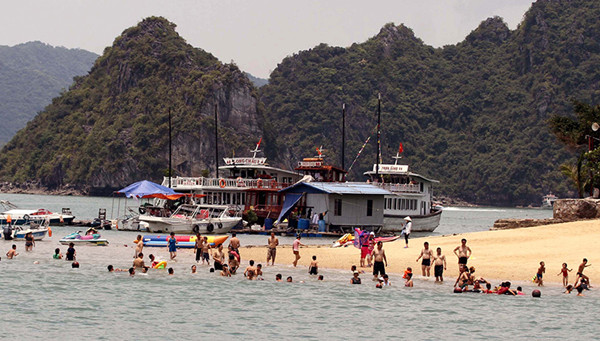 游客特别喜欢在海滩上玩水。（图片来源：人民报网）