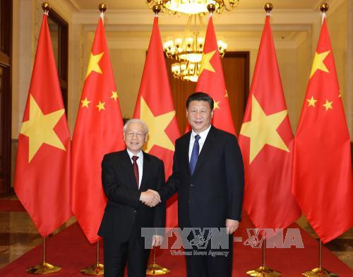 两国领导人亲密握手（图片来源：越通社）