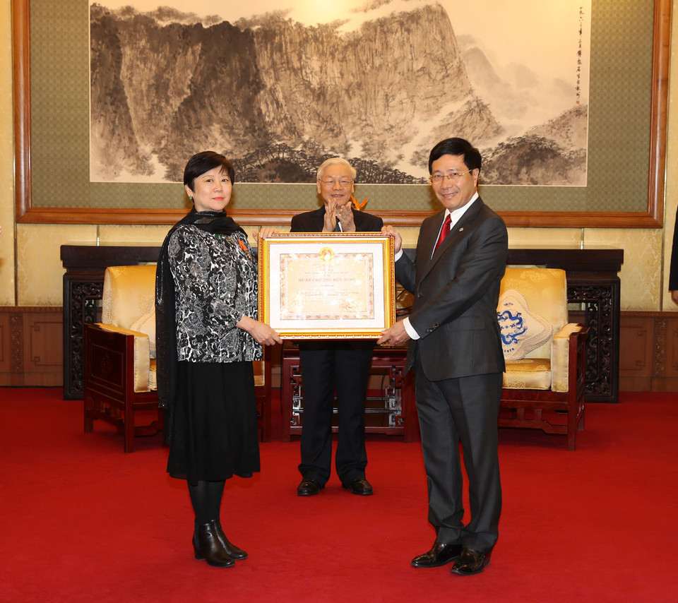 受越南国家主席的委托，政府副总理兼外长范平明向中国人民对外友好协会会长李小林女士授予友谊勋章。（图片来源：越通社）（图片来源：越通社）