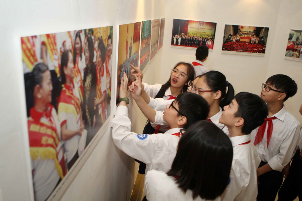 参观“爱国竞赛运动70周年"图片展的少年儿童。（图片来源：越通社）