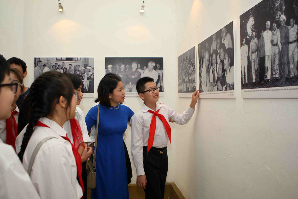 参观“爱国竞赛运动70周年"图片展的少年儿童。（图片来源：越通社）
