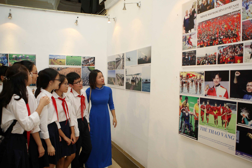 参观“爱国竞赛运动70周年"图片展的少年儿童。（图片来源：越通社）