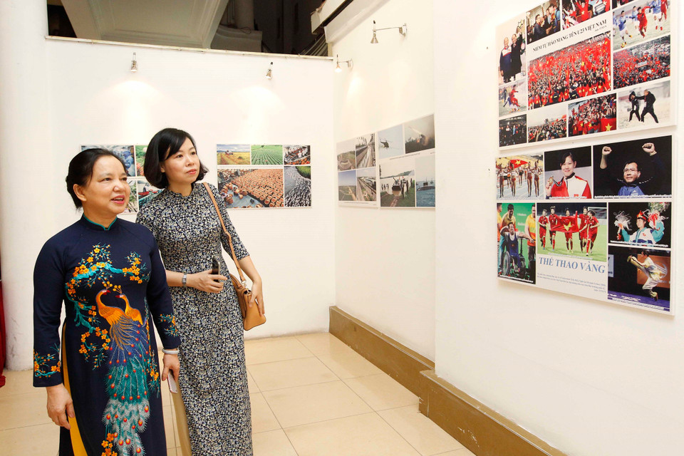 “爱国竞赛运动70周年"图片展的参观者。（图片来源：越通社）