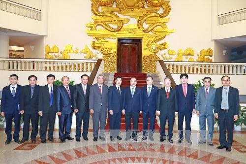 政府总理阮春福与老挝人民革命党中央政治局委员、万象市委书记兼市长辛拉冯·库派吞一行合影。（图片来源：越通社）