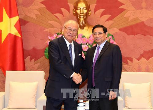 越共中央政治局委员、中央书记处书记、中央组织部部长、越日友好议员小组主席范明正（右）3月16日在国会大夏会见了来访的日越友好议员联盟特别顾问武部勤。（图片来源：越通社）