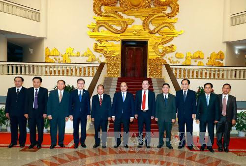 政府总理阮春福（中）与老挝安全部部长宋乔•西拉冯合影。（图片来源：越通社）