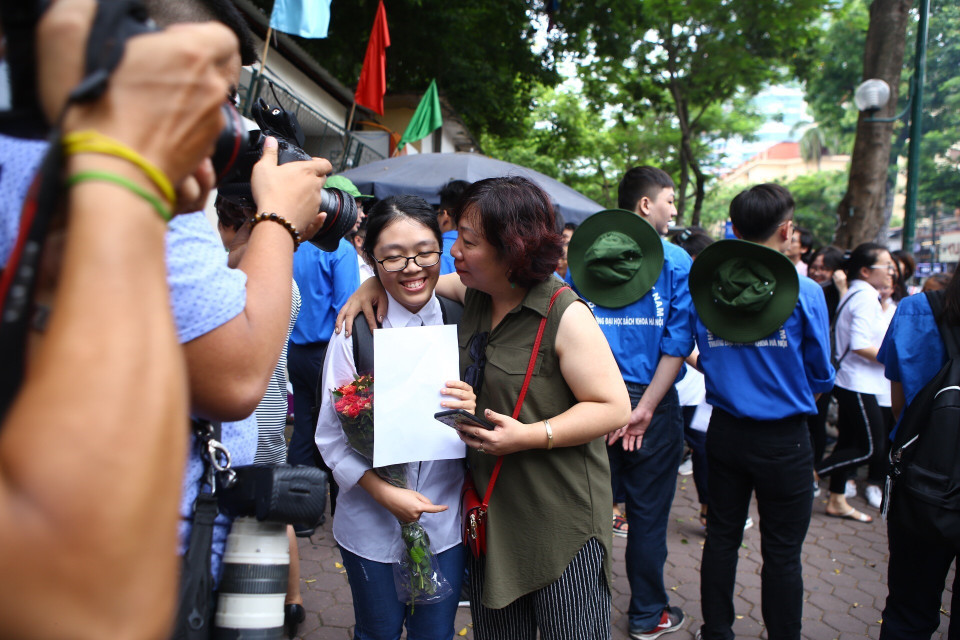 一名学生与校外的父母说着这次考试题目的难度。（图片来源：越通社）