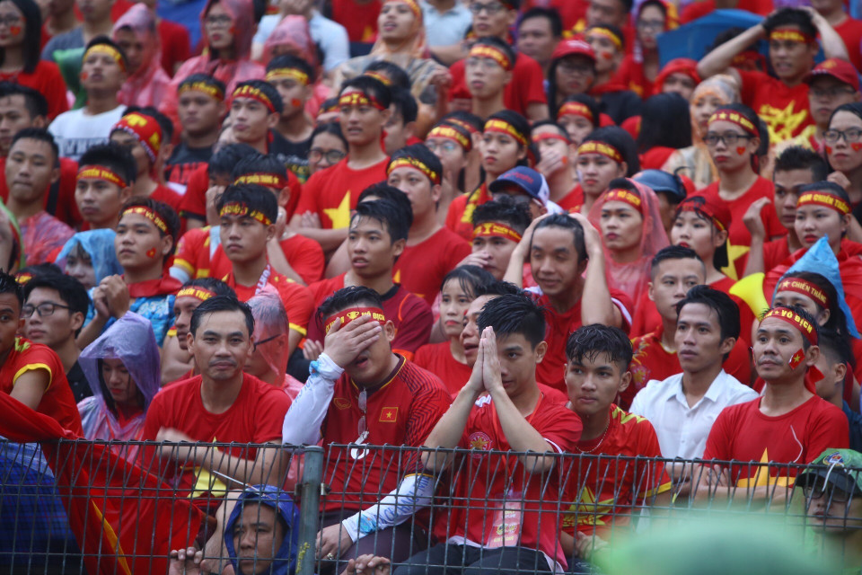 越南球迷一边淋雨一边为喜爱的球星呐喊助威。图自越通社