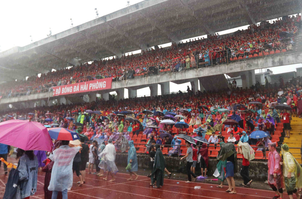 一场大暴雨并没有对看台上的球迷造成什么影响，大家仍然可以心无旁骛地看球。图自越通社