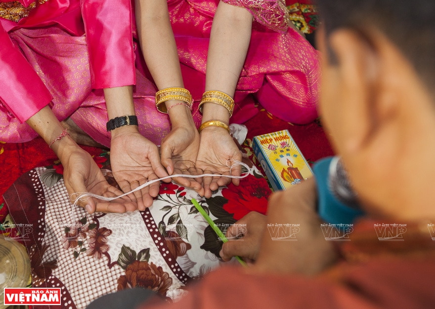 新郎新郎拴线仪式。越南画报记者 阮伦 摄