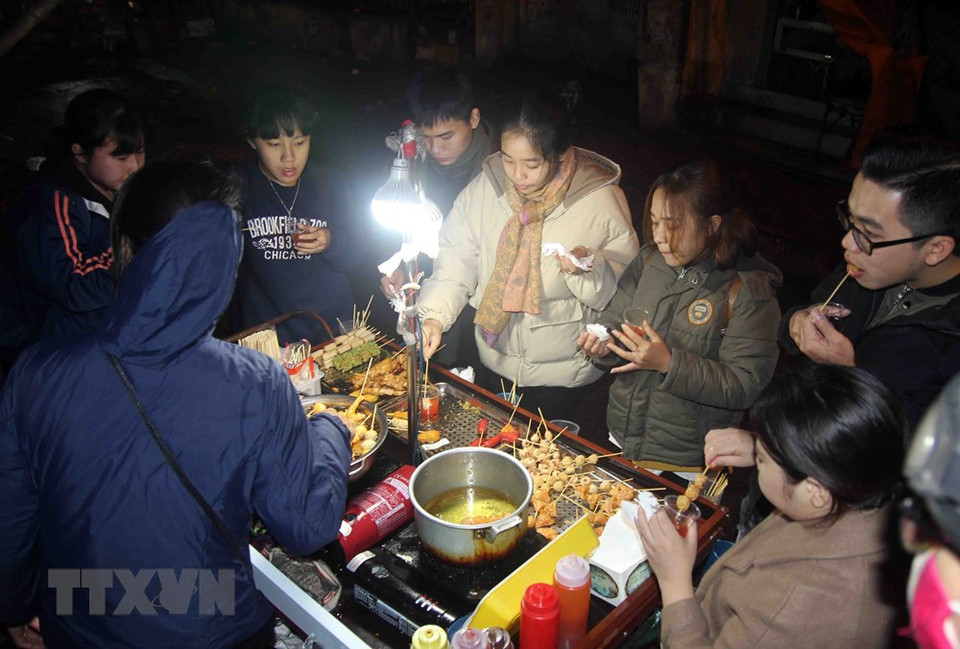 年轻人们吃小吃抗严寒 越通社记者 光决 摄