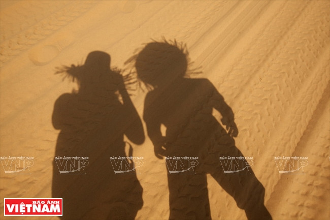 在沙丘上拍照的游客（图片来源：越通社）