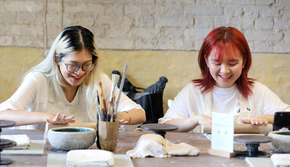 年轻人饶有兴趣地体验手工陶瓷制作的乐趣。图自 越通社/《越南画报》