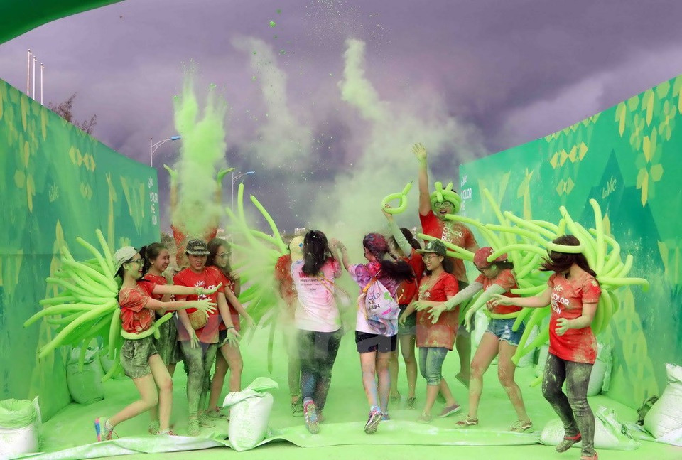 6月25日在岘港市举行的“彩色跑——Color Me Run”活动。参观者从头到脚抛撒彩色粉末（图片来源：越通社）