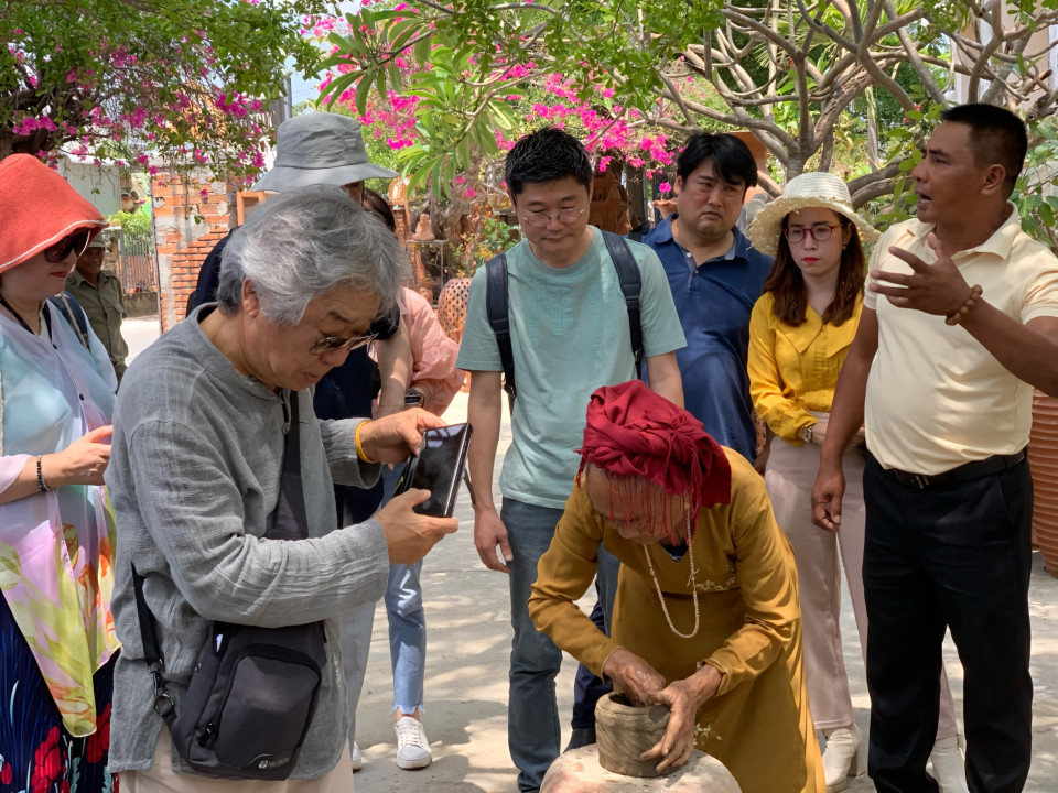 韩国游客参观并了解位于宁福县福民镇宝竹村占族同胞传统陶瓷制作业。图自越通社