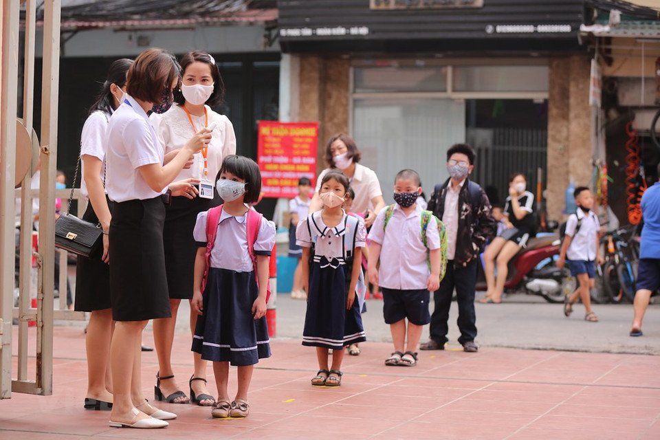 进入学校之前，学生门要排队进行体温测量和洗手。越通社记者 明山 摄