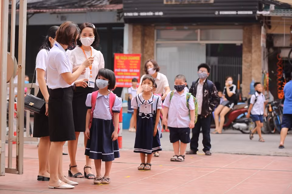 进入学校之前，学生门要排队进行体温测量和洗手。越通社记者 明山 摄