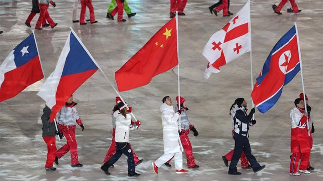 各国运动员手举国旗在闭幕式上入场。（图片来源：人民报网）