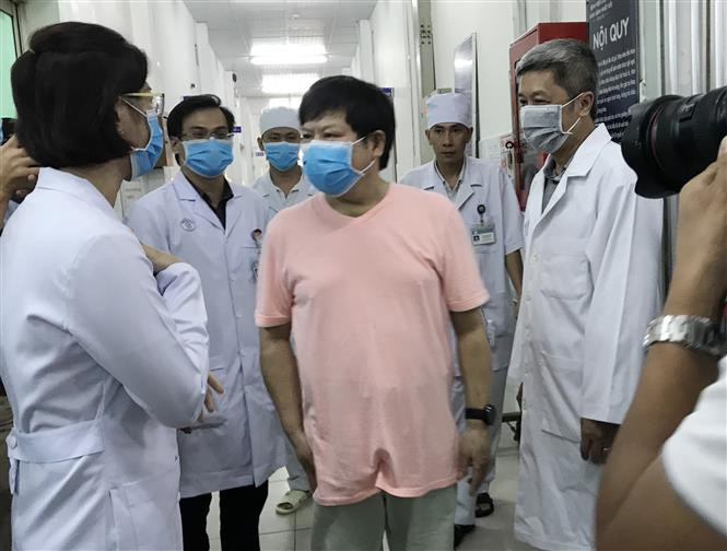 中国籍患者 Li Ding (粉红色T恤)迈出大水镬医院的隔离区。越通社记者 丁恒 摄