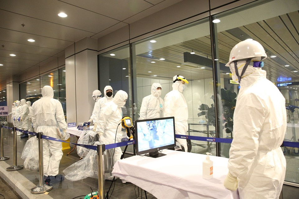 公民办理手续前测量体温、进行全身消毒等。越通社记者 杨江 摄