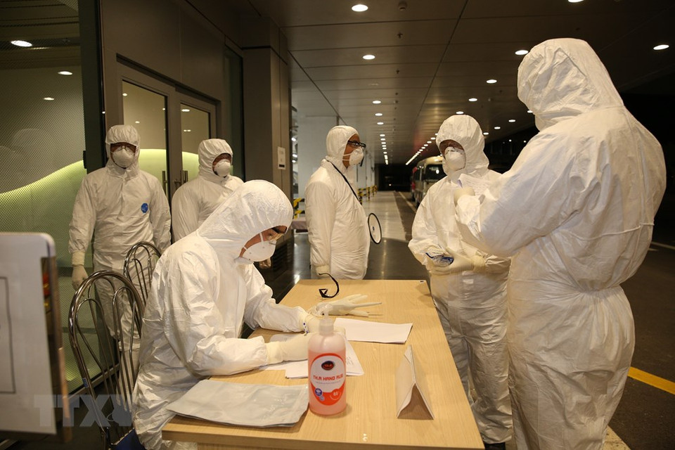 云屯国际机场人员为从中国武汉市归来的越南公民办理入境手续。越通社记者 杨江 摄