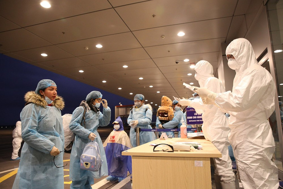 云屯国际机场人员为从中国武汉市归来的越南公民办理入境手续。越通社记者 杨江 摄