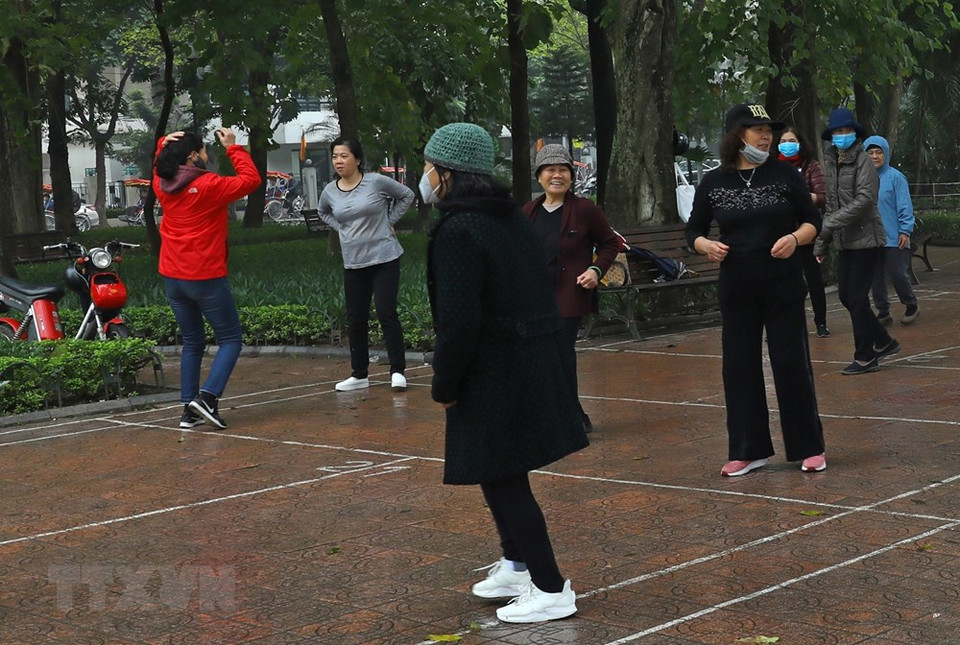 居民们每天依旧在湖边一起做早操。图自越通社