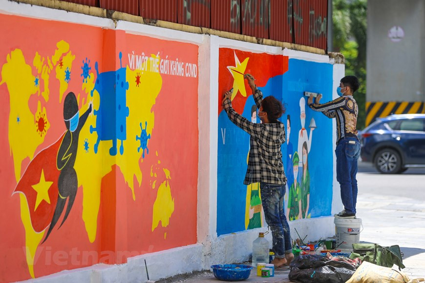 在全国都在竭尽全力抗击新冠肺炎疫情的背景下，河内市街头墙壁上的壁画成为抗击疫情的一种宣传方式。每一幅壁画作品生动地描绘疫情防控的不同内容。每当人们经过武仲庆街时，这些壁画都会吸引住他们的眼球。壁画既有宣传内容，又有鼓励内容，让人们严格遵守卫生部的防疫规定。图自Vietnam+