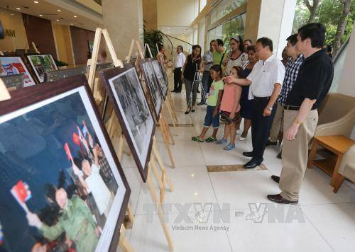 越通社副社长黎维传和与会代表参观图片展。(图片来源:越通社)
