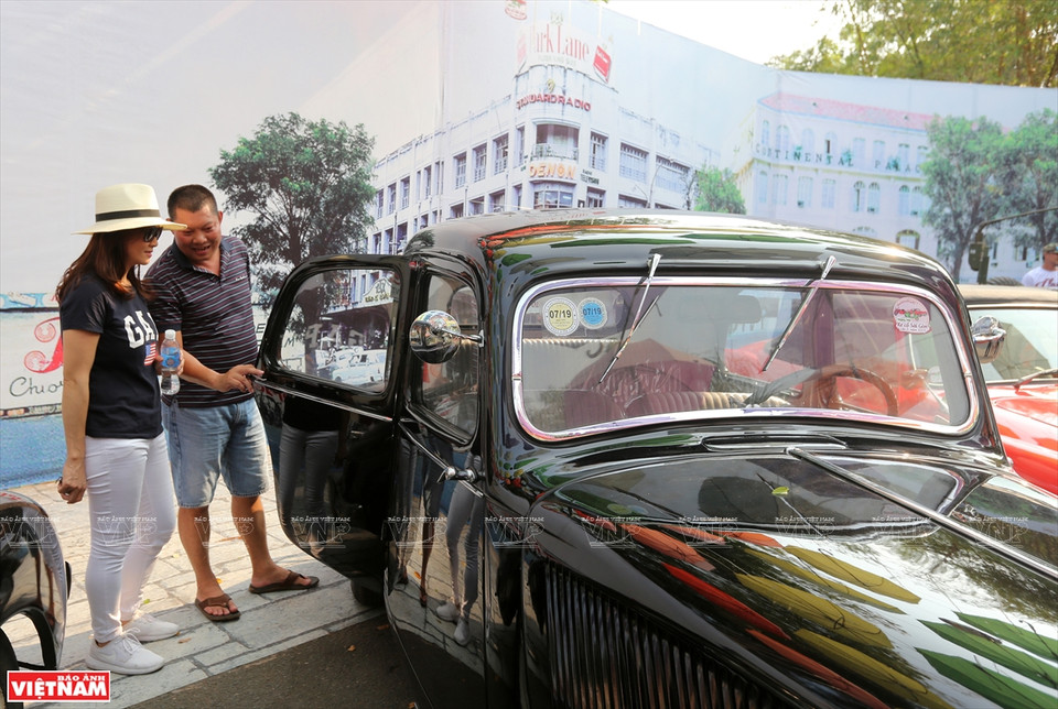 经典老车车主向参观者介绍经典老车历史来源。图自 越通社