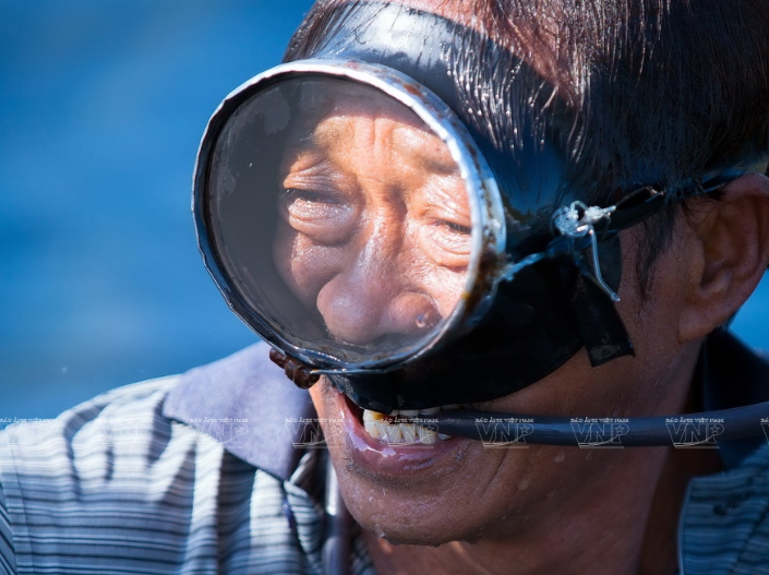 每天渔民们都要在海底深处给龙虾投喂饲料。图自越通社