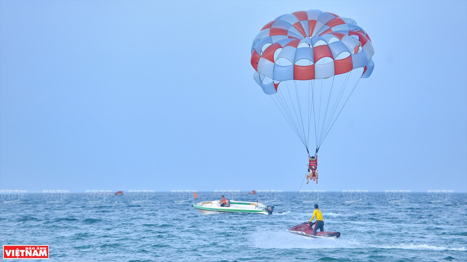游客们在海上高空飞行滑翔伞。越通社记者 青和 摄