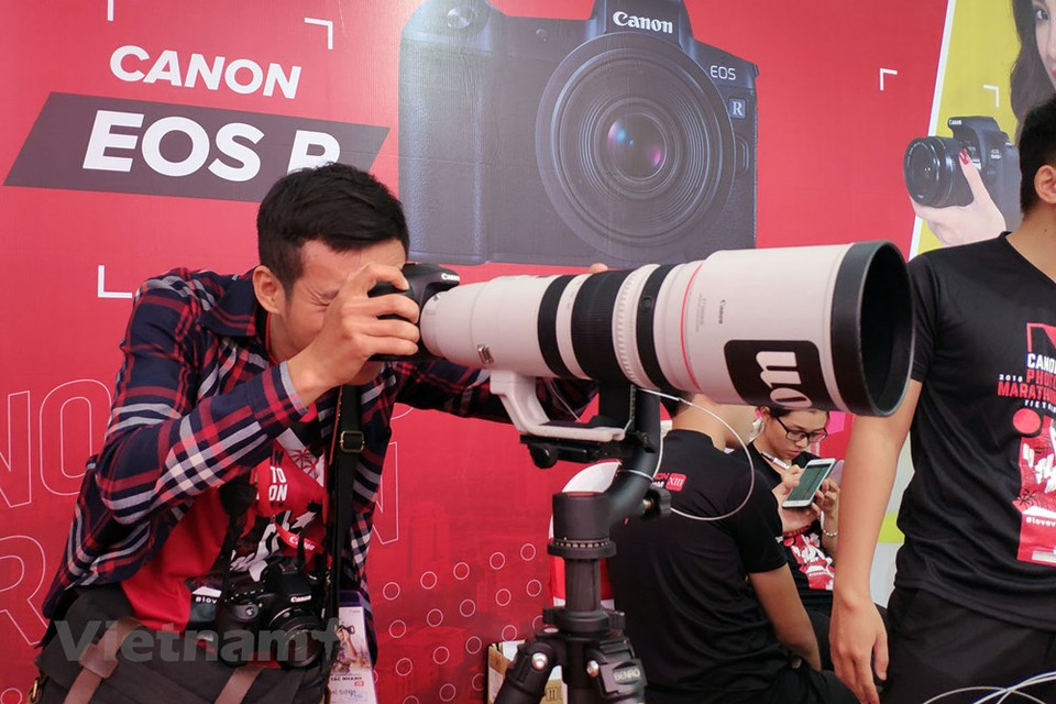 参赛者试验佳能的现代设备。图自越通社