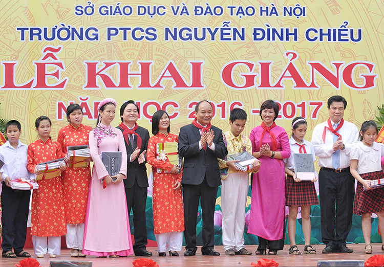 越南政府总理阮春福向河内市二征夫人郡阮廷沼初中学校贫困学生赠送礼物。