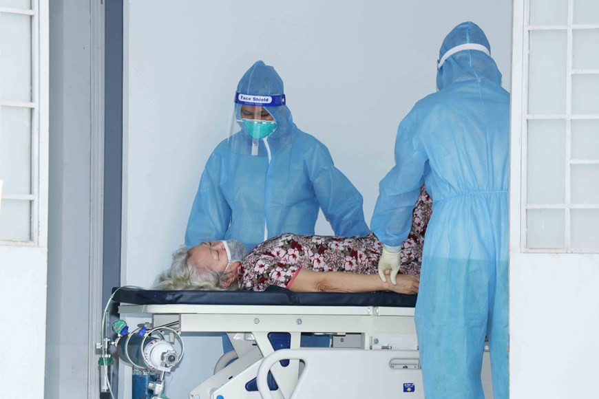 平政县永禄B乡四号野战医院医护人员对新冠肺炎患者进行治疗。图自越通社