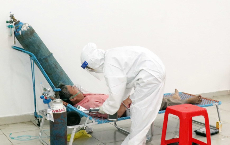 医生对患有基础性疾病的无症状患者进行看病。图自越通社