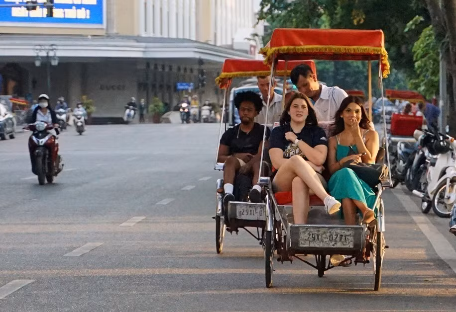 国际游客乘坐越式三轮车漫游还剑湖。图自越通社