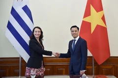 越南外交部副部长邓黄江与乌拉圭外交部副部长瓦莱里娅·楚萨基·卡夫雷拉。外交部供图
