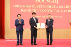越共中央政治局委员、中央书记处书记、中央组织部部长黎明兴向陈辉俊同志颁发决定。图自越通社
