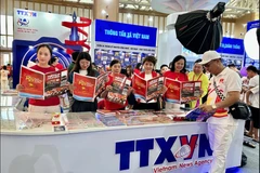 游客参观越南国庆80周年国家成就展上的越通社展位。图自越通社