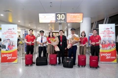 越捷航空领导与机组人员和乘客合影。越捷航空供图