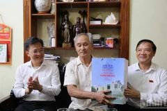 越共中央委员、国会副主席阮克定向伤残军人范文良赠送慰问品。图自《人民报》
