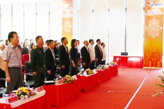 收看越共十四大开幕式的电视直播的代表们。图自越通社