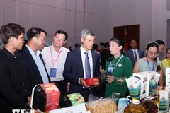 越南驻柬大使阮明宇和柬埔寨企业代表参观越南展位。图自越通社